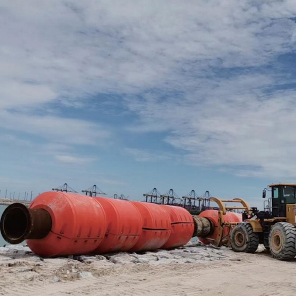 Pipe fitted with orange floats beside site equipment